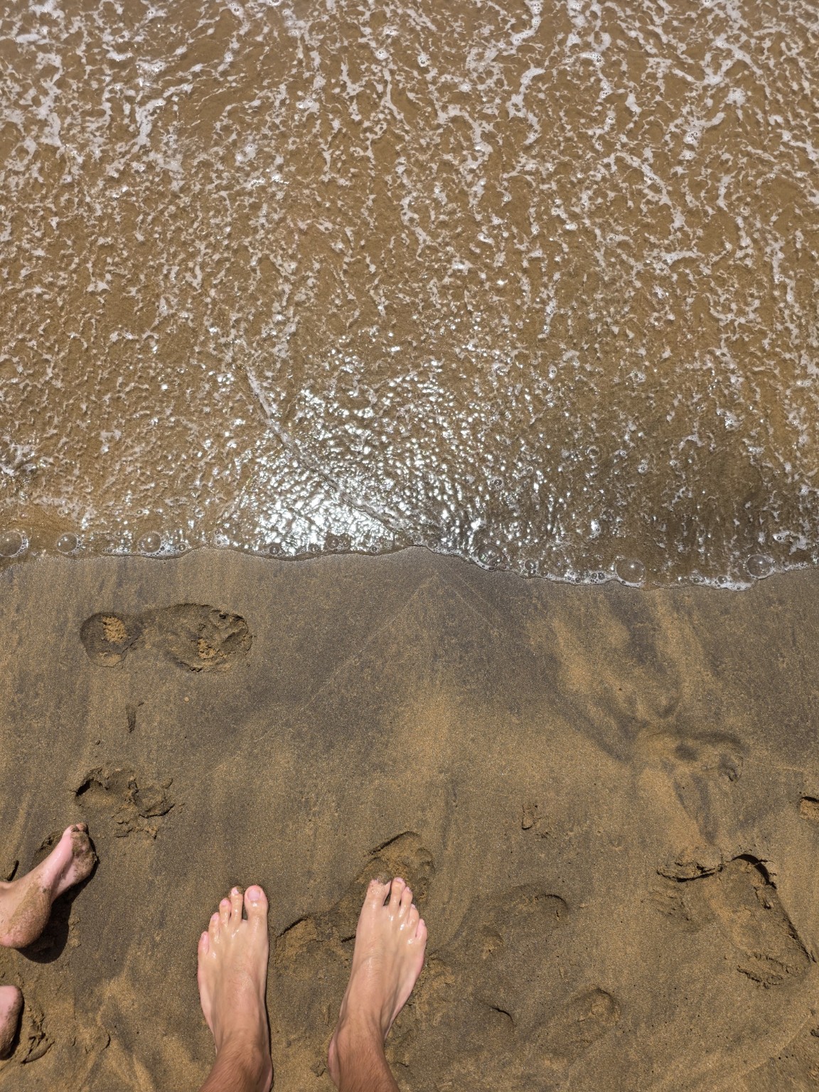 Złoty piasek i ślady stóp przy brzegu Playa Larga