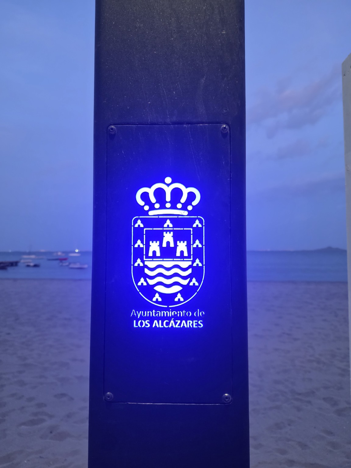 Podświetlony herb Los Alcázares przy plaży